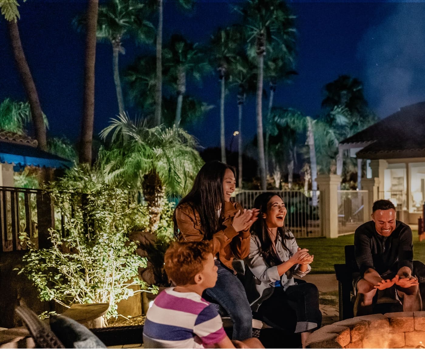 Family and friends sitting around a fire pit